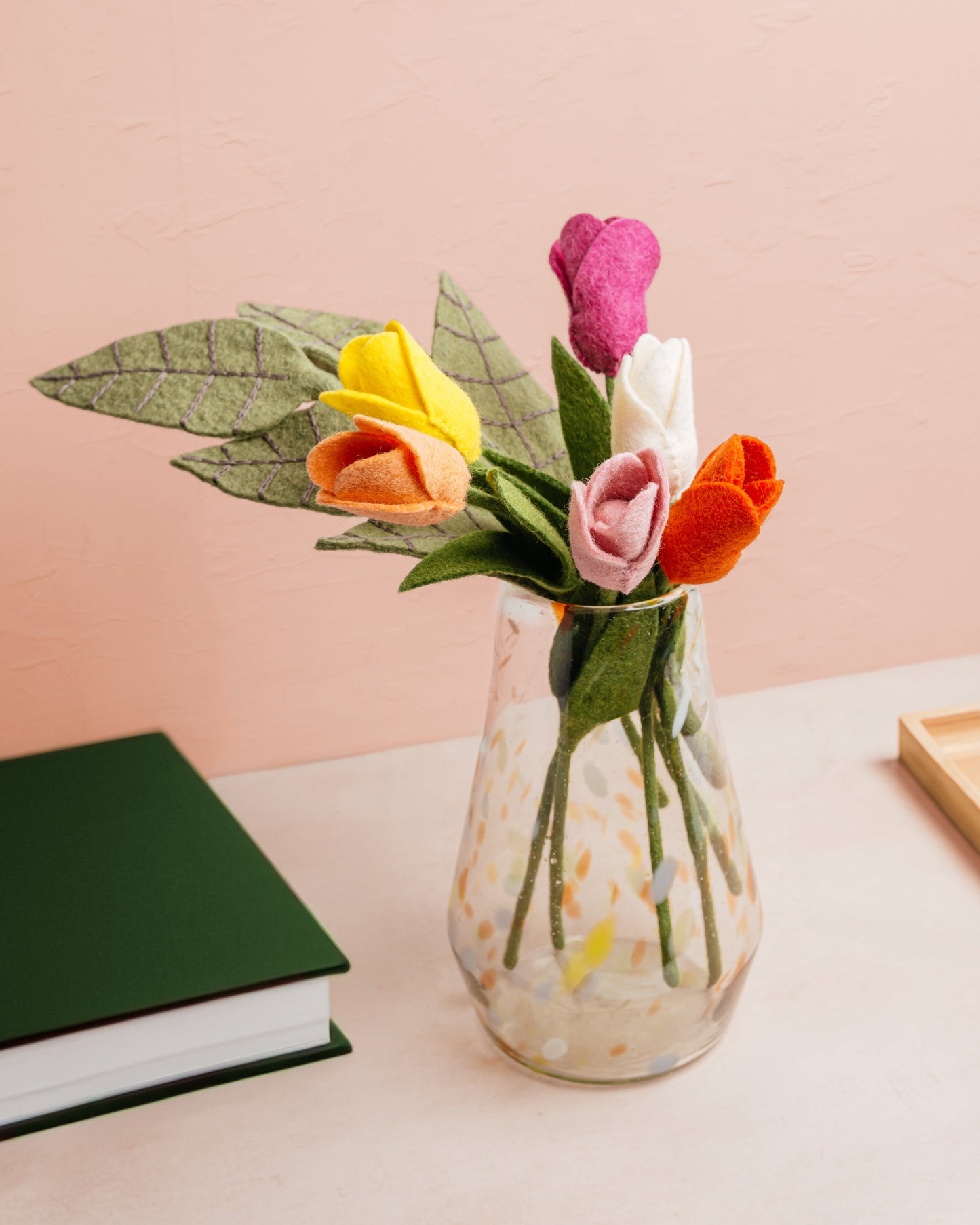 Glass vase with orange, yellow, pink, and white felt tulips.
