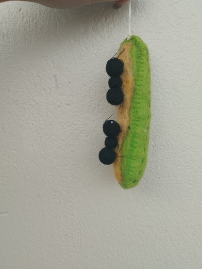 Felt ornament of Ants on a Log snack of celery with peanut butter and raisins on top.