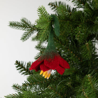 Felt ornament of a red flower on a Christmas tree.