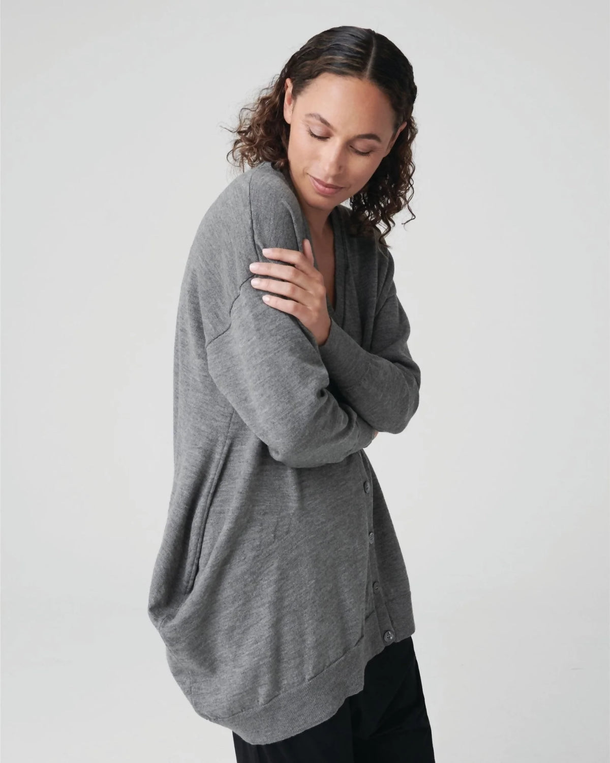 Side view of woman wearing grey cardigan.