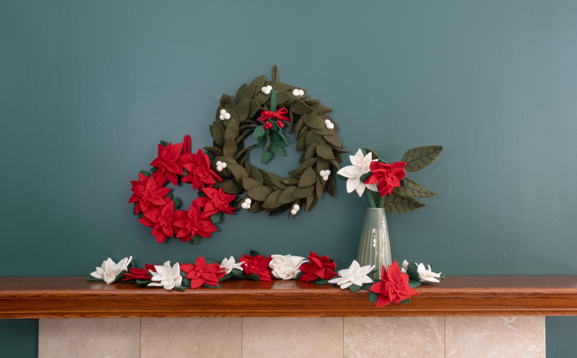 Felt ornament of Holly with berries and a red bow hanging with various wreaths.