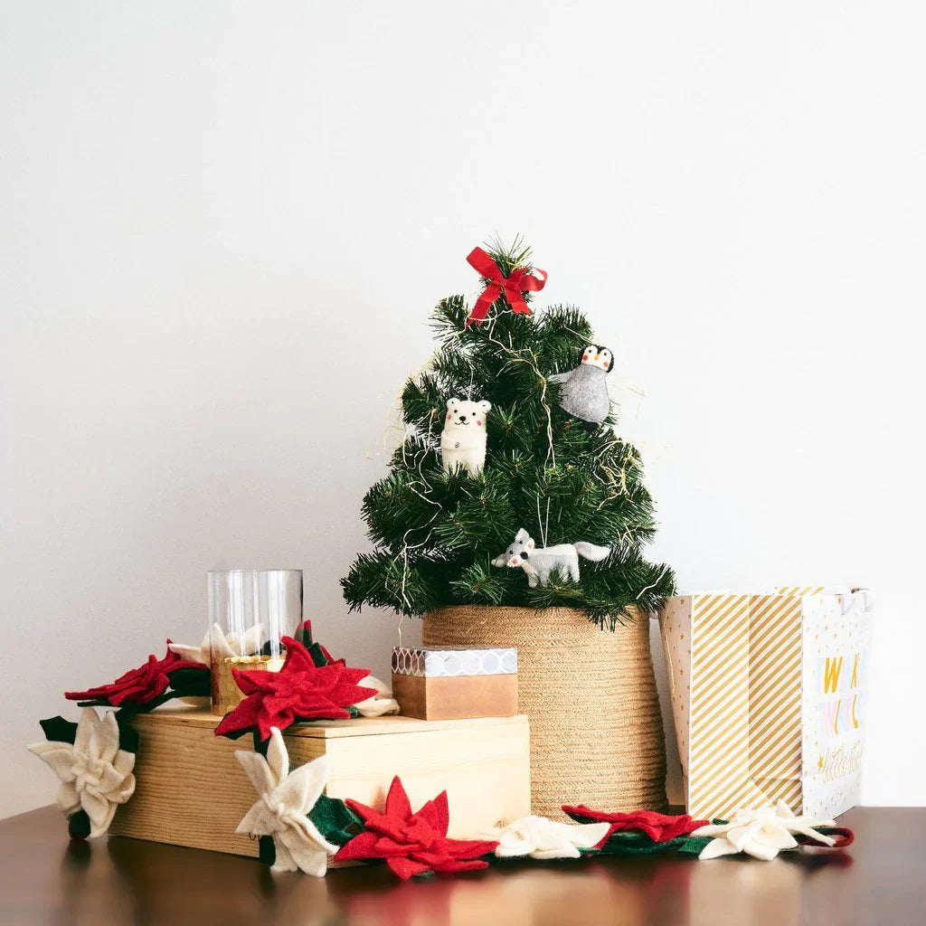 Mini Christmas tree with ornaments of felted wool arctic animals and presents underneath.