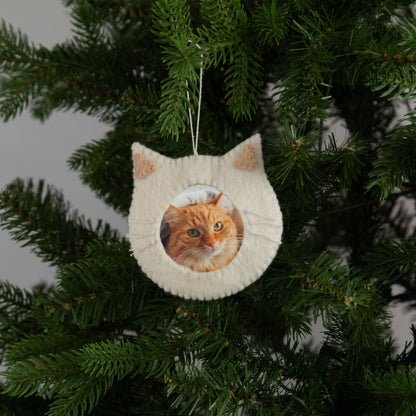 Felt ornament of a white cat face outline with a photograph of an orange cat in the middle.
