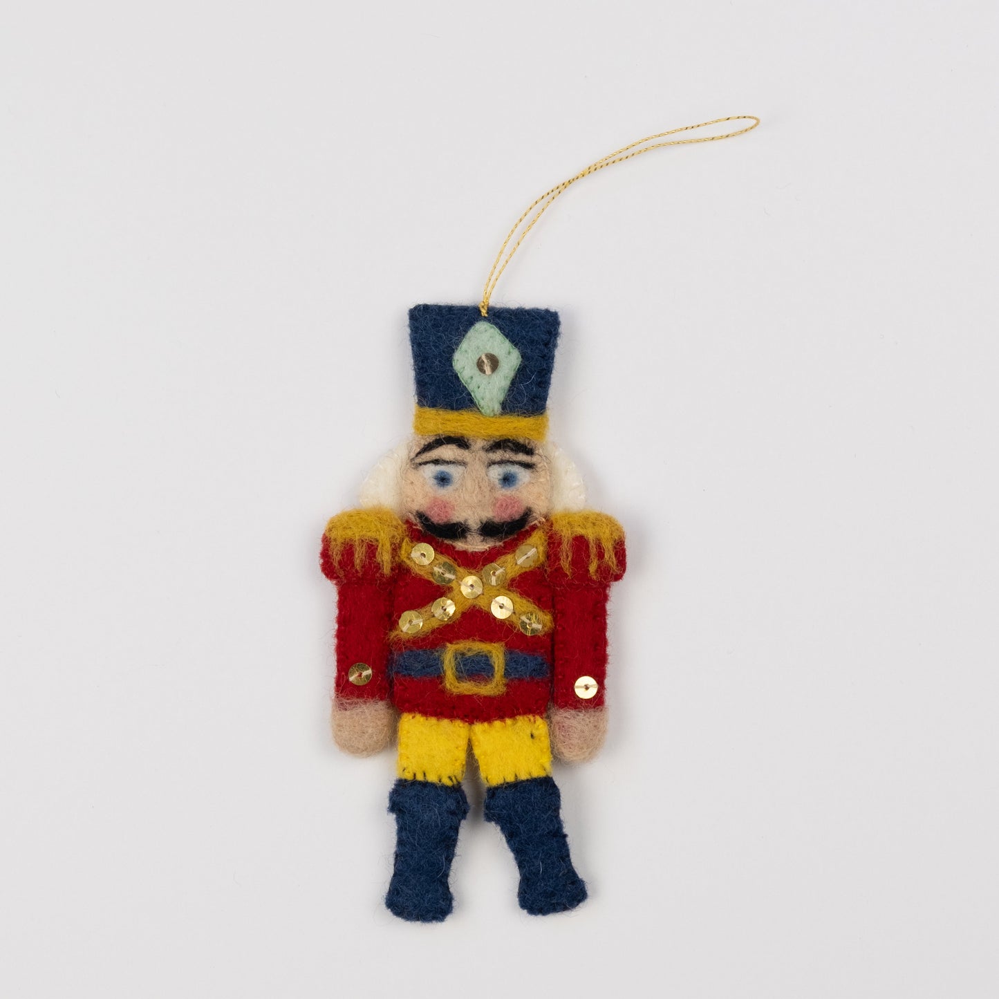 Felt ornament of a red and gold nutcracker.