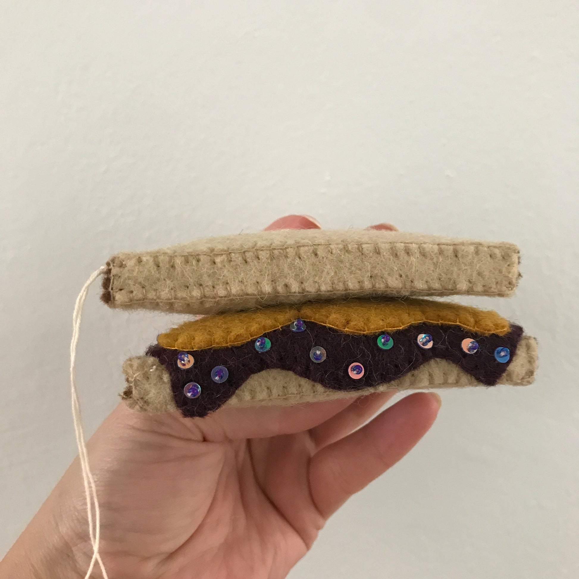 Close up side view of felt PB&J ornament.