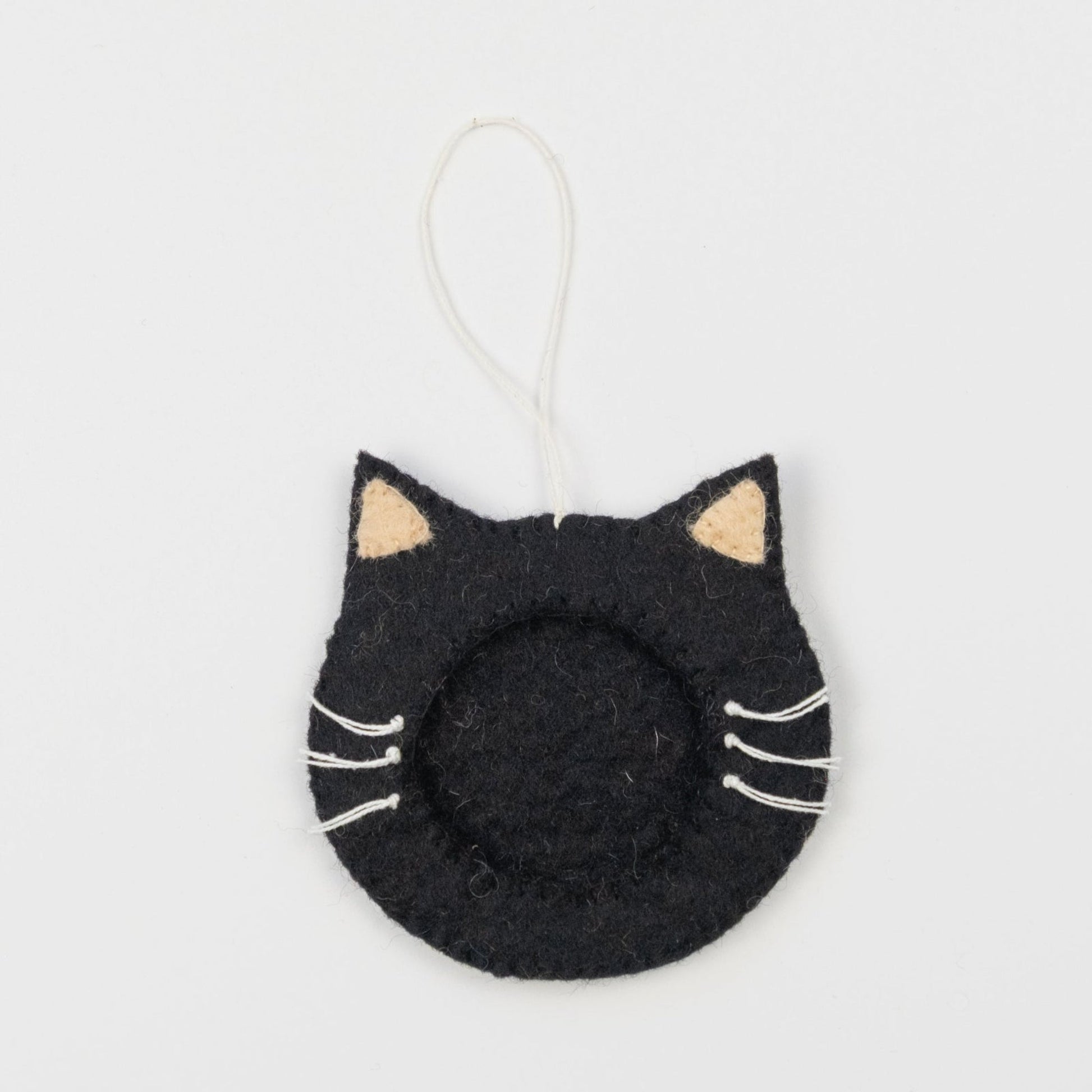 Felt ornament of a black cat face outline with a frame in the middle to put a photograph.