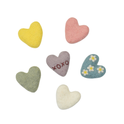 Set of fair trade colorful heart-shaped kids toys on a light gray background.