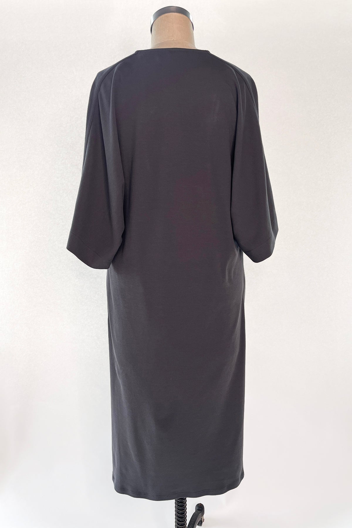 Back view of Knitted Orbis dress in iron color on mannikin.