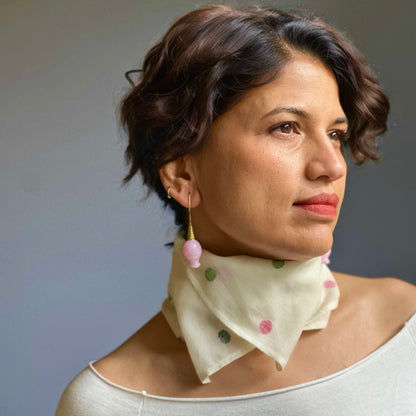 Front right view of woman wearing pink glass earrings with gold plated findings.