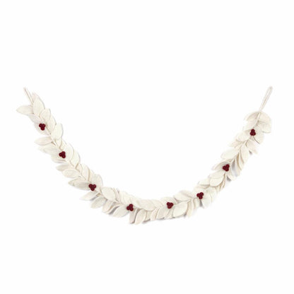 Felt garland with white leaves with red berries hanging on wall.