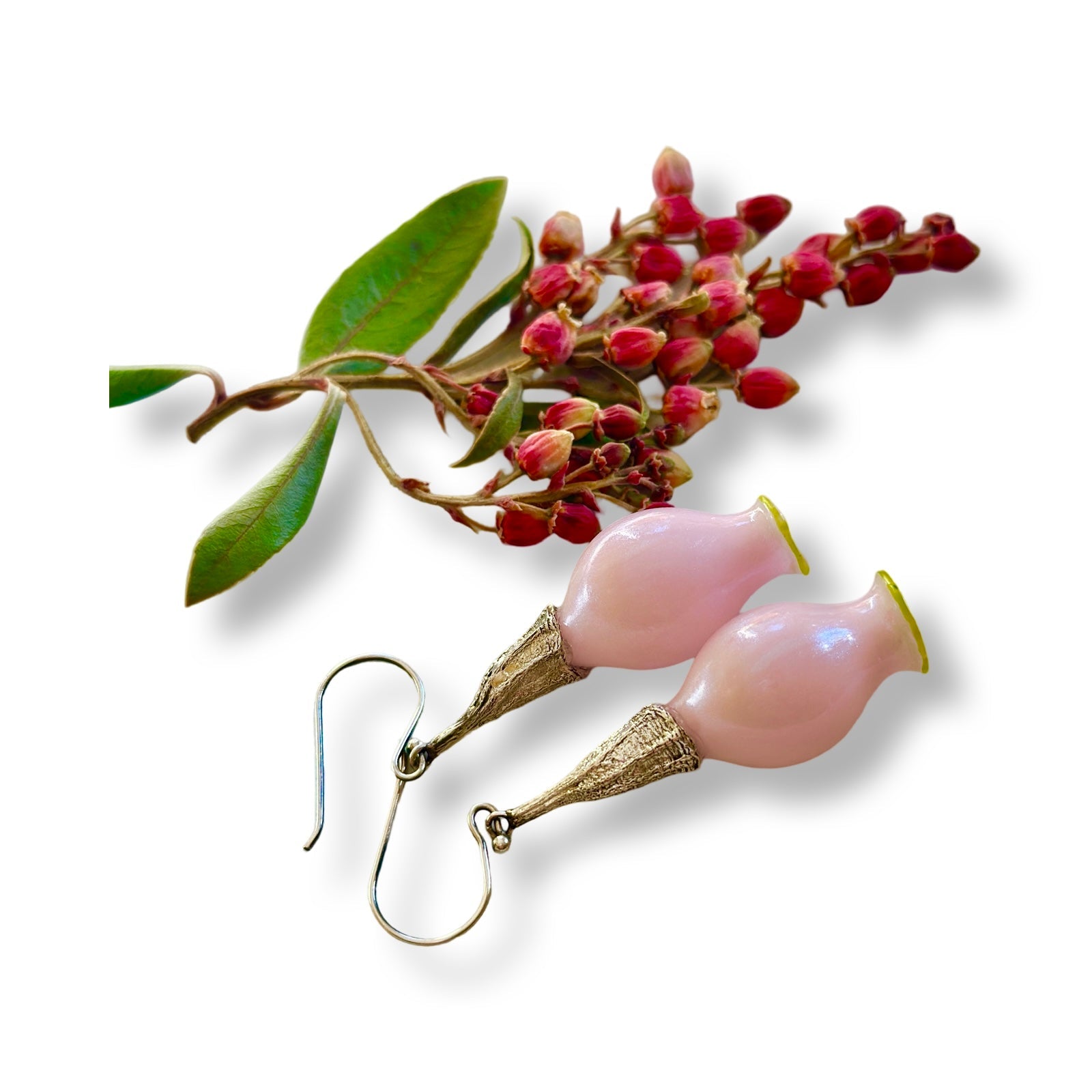 Pair of iridescent pink pod glass bud earrings with silver findings and branch with red seeds.