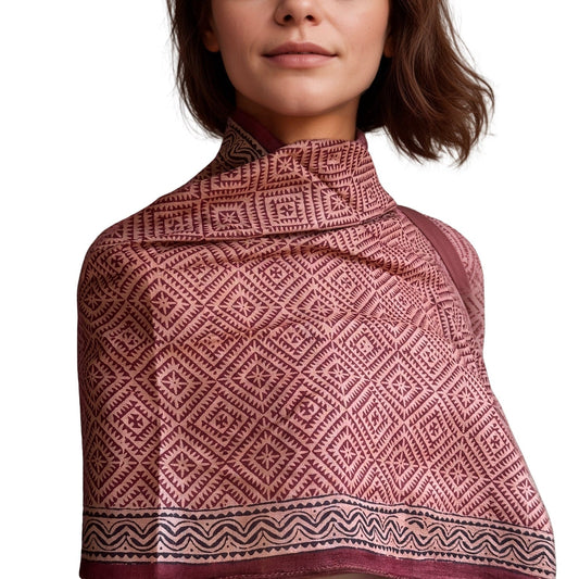 Woman wrapped in red, natural, black geometric design stole.