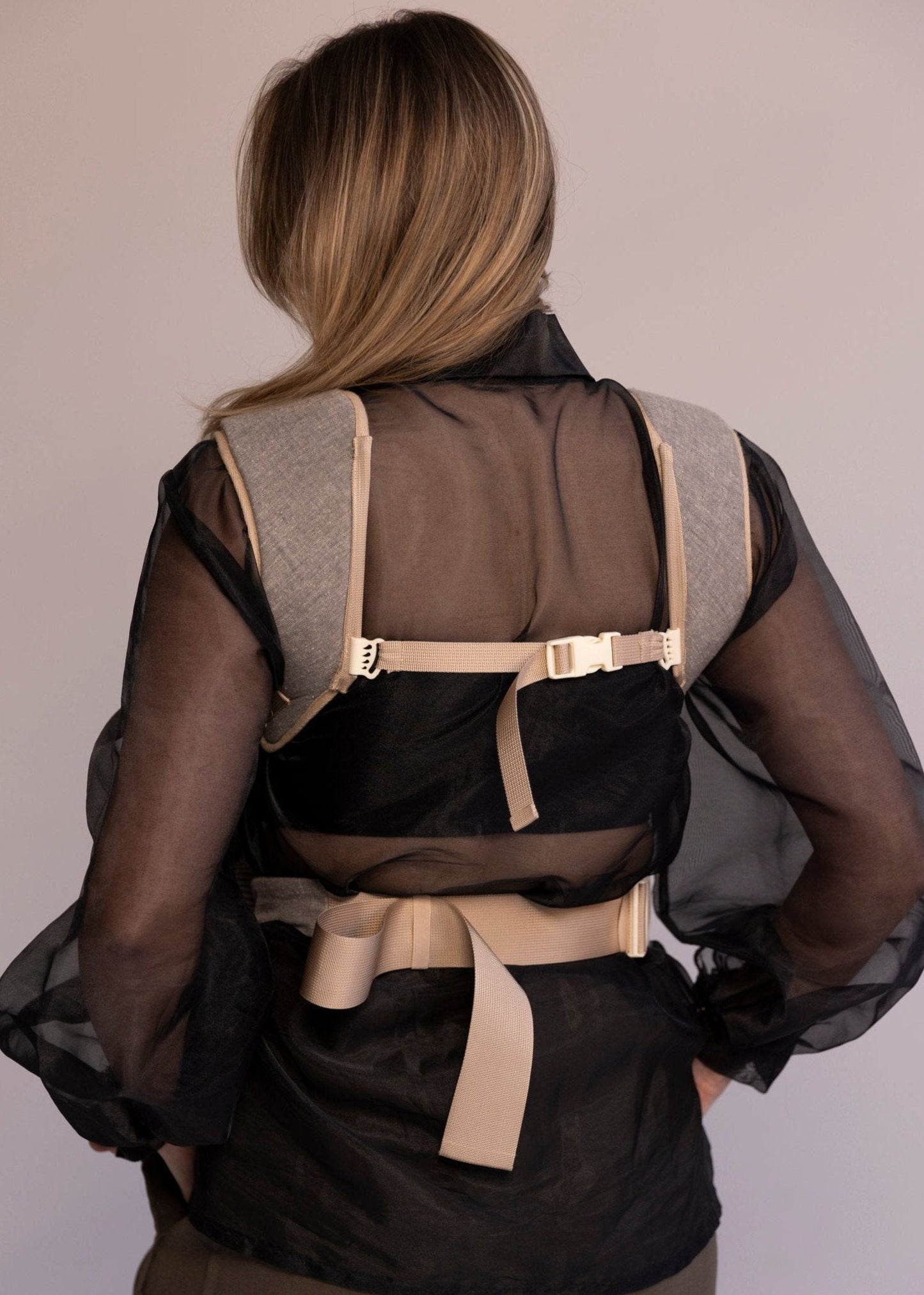 Back view of baby carrier on woman.