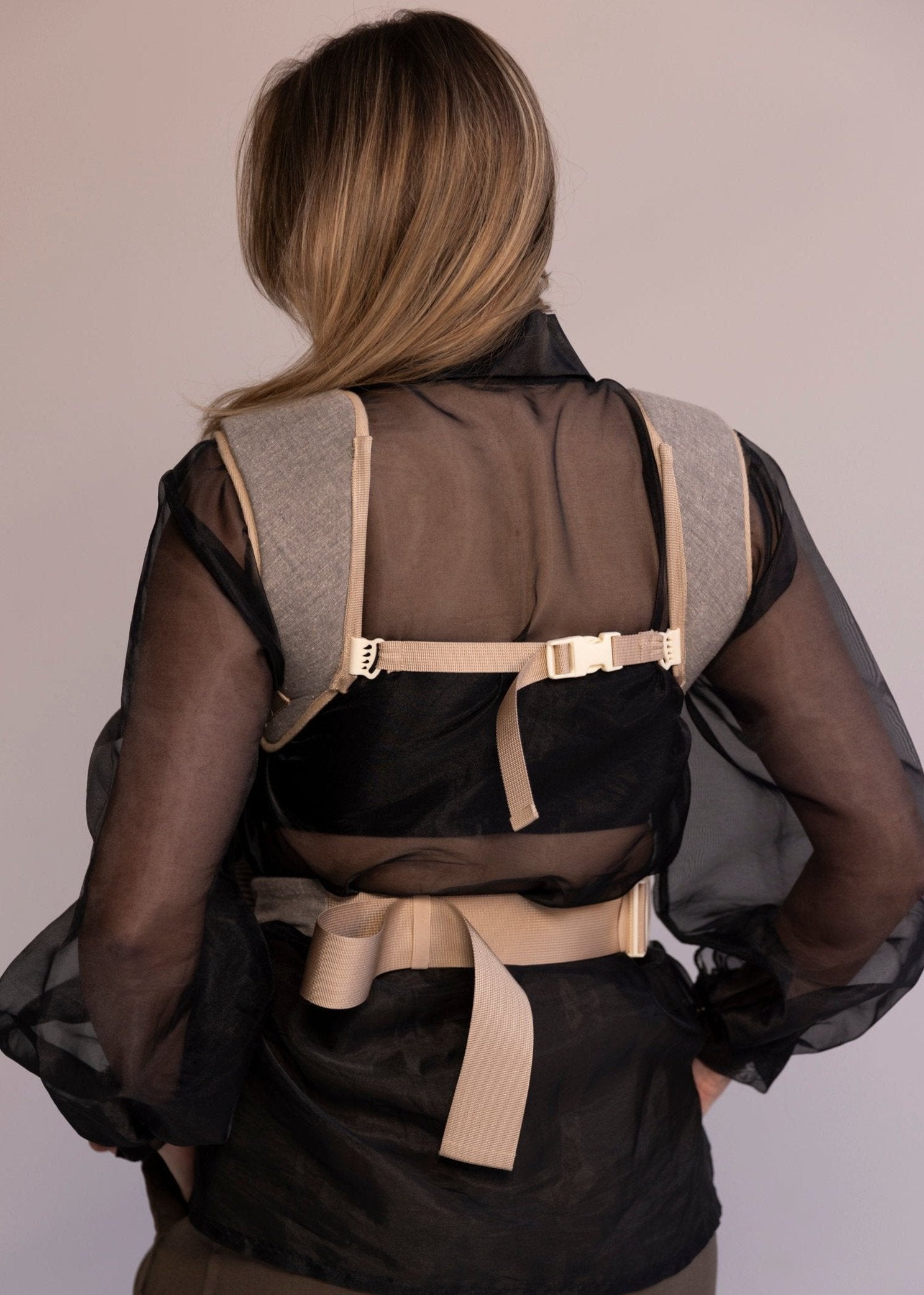 Back view of baby carrier on woman.
