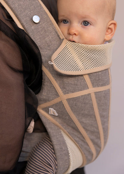 Closeup of baby in grey with tan stripes baby carrier.