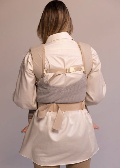 Back view of woman wearing corset baby carrier.