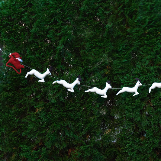 Felt garland red Santa and sleigh with white reindeer on Christmas tree.