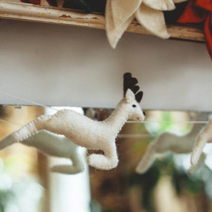 Felt garland close up of white reindeer.