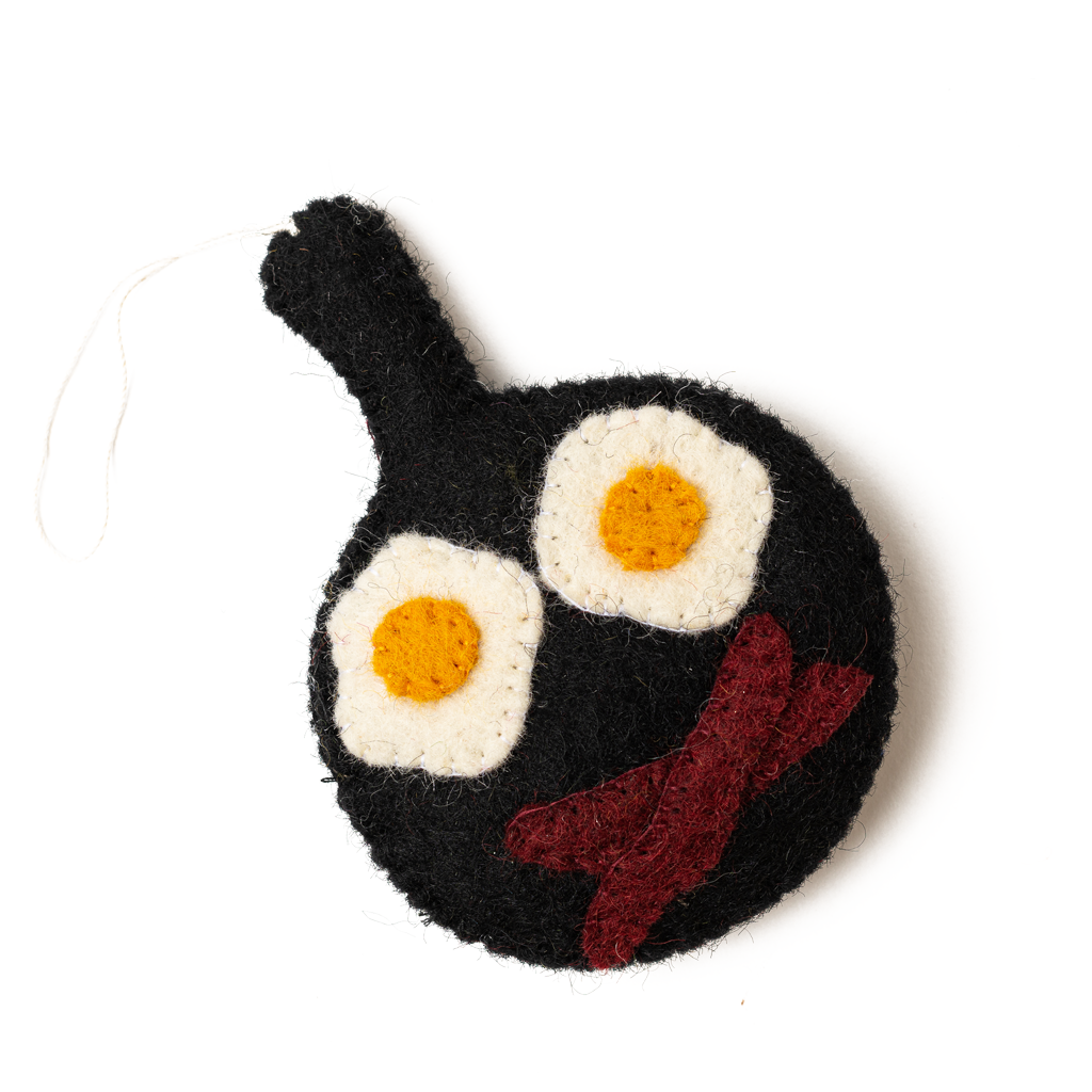 Felt ornament of a fry pan with eggs and bacon in it.