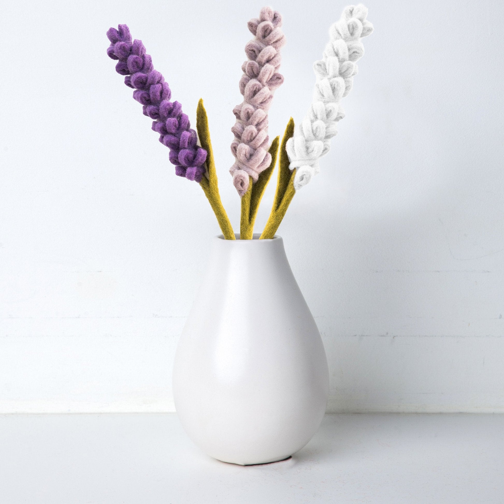 Felt Lavender flowers in purple, light purple, and white in a white vase.