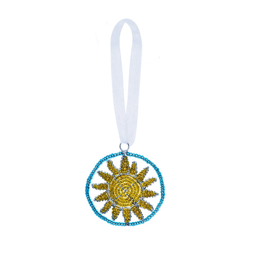 Beaded ornament of a yellow sun in a blue circle.