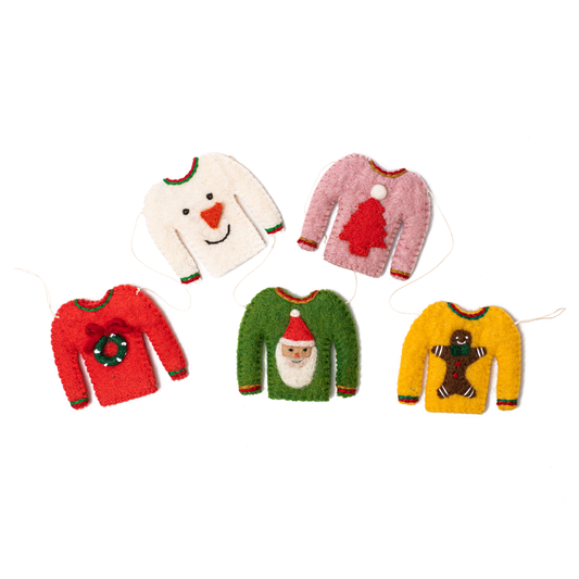 Tiny sweaters, one red with a wreath, white with snowman, pink with red tree, green with Santa, and yellow with a gingerbread man.