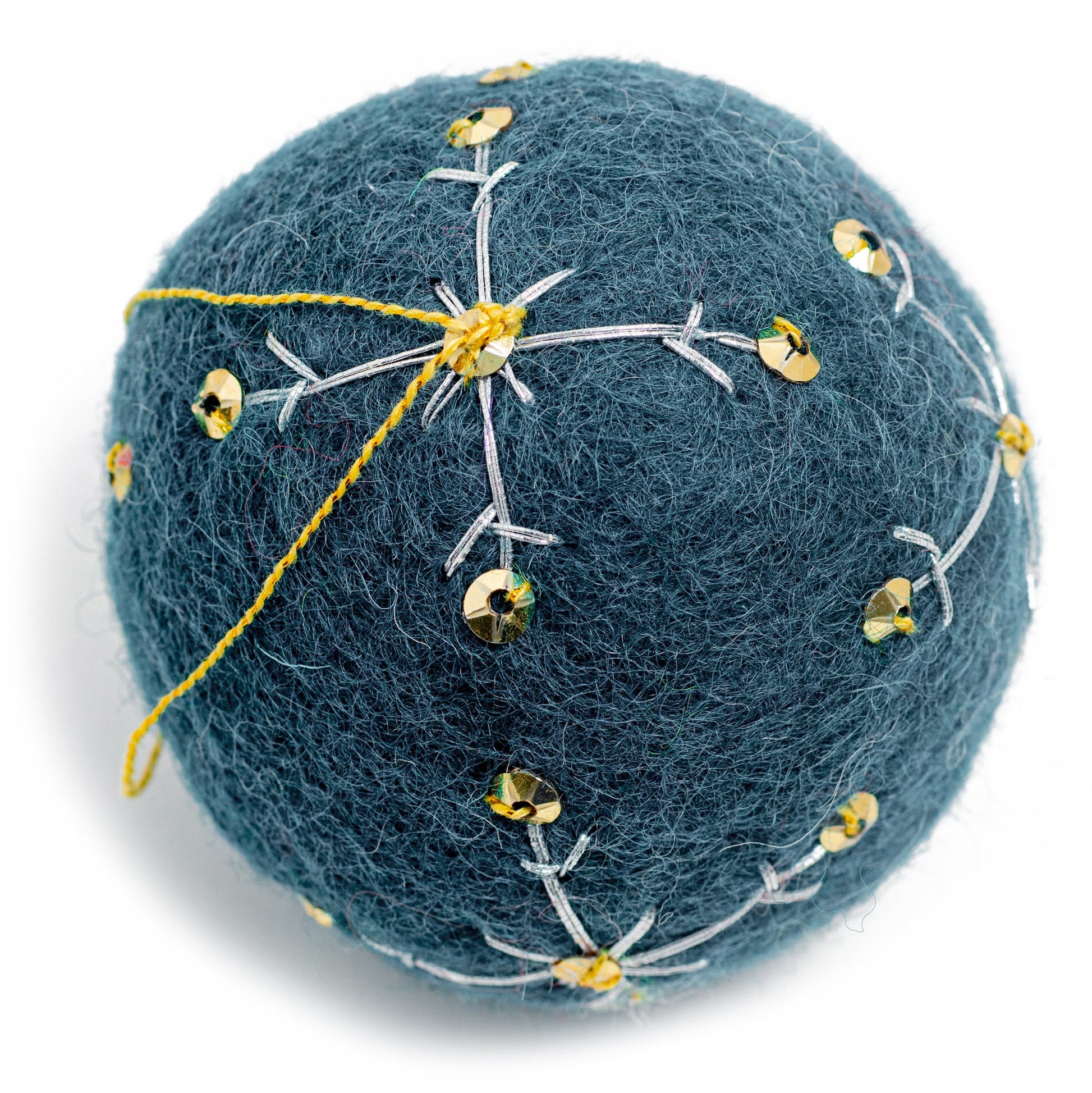 A dark blue round felt ornament with white embroidery and gold sequin designs.