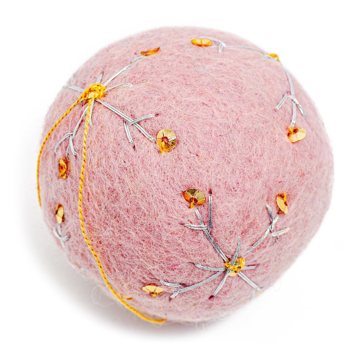 A round, light pink felt ornament with white embroidery and gold sequin designs.