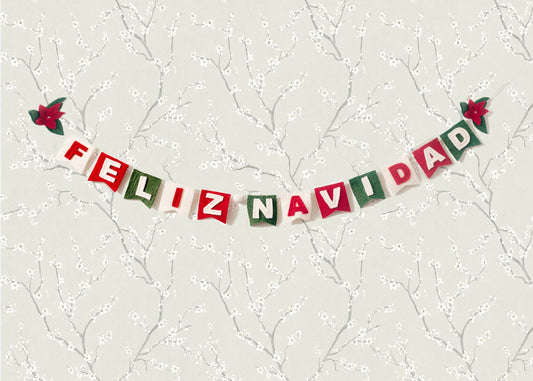 Felt garland spelling out Feliz Navidad in red and white letters on small dovetail flags in white, red, and green.