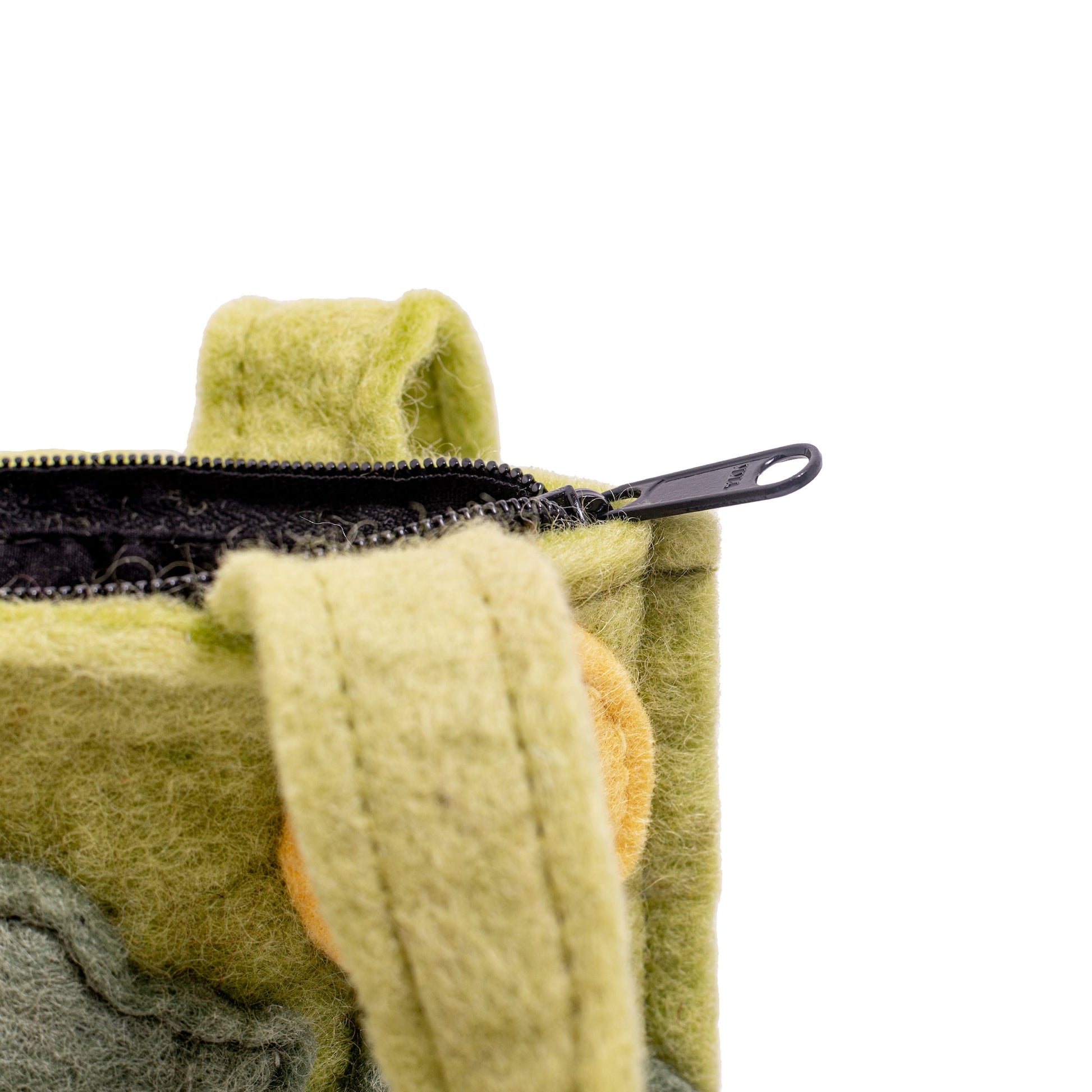 Close up of black zipper at the top of a green puppet bag.