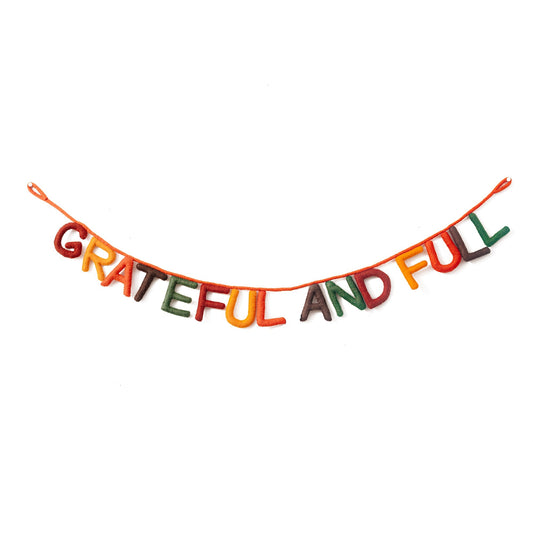 Hanging felt garland spelling out Grateful and Full each letter in different colors of red, yellow, orange, brown, and green.