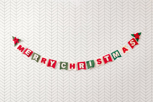 Felt garland spelling out Merry Christmas in red and white letters on small dovetail flags in white, red, and green.