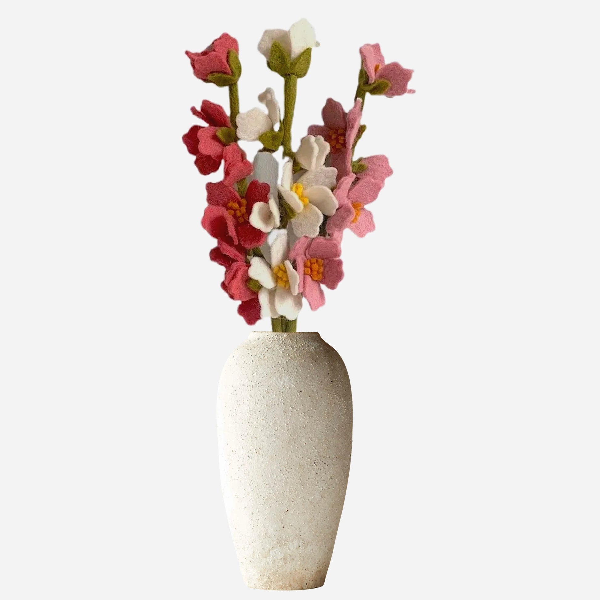 Pink, white, and green felt floral arrangement in a white vase.
