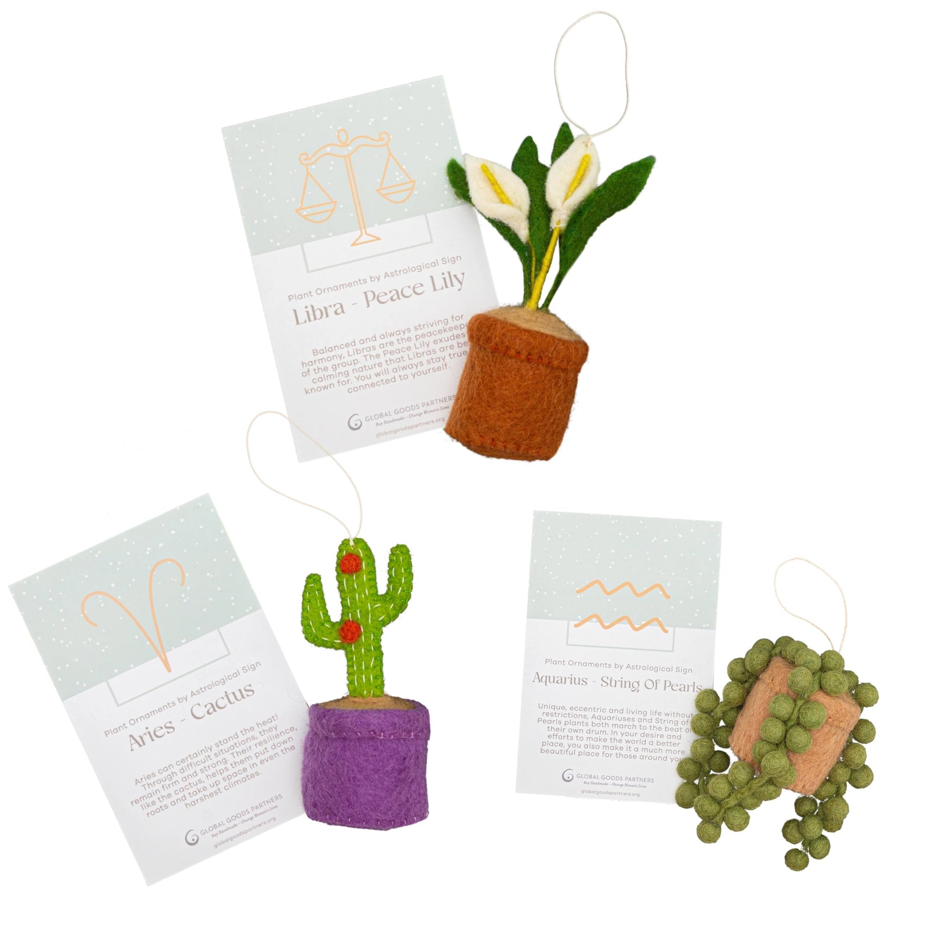 Felt zodiac ornaments of a cactus with Aries astrology card, a peace lily with Libra card, and a String of Pearls plant with an Aquarius card.