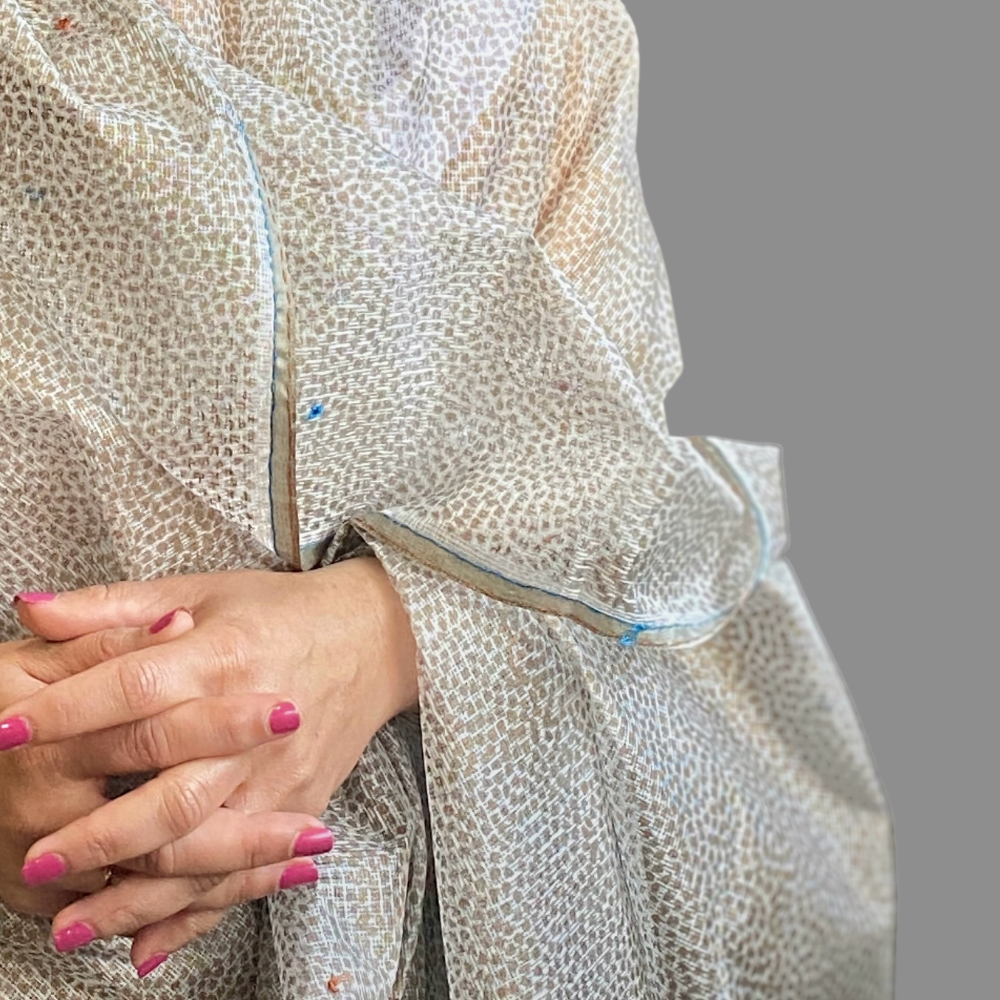 Closeup of woman in white and light brown dotted should wrap.  Only hands showing.
