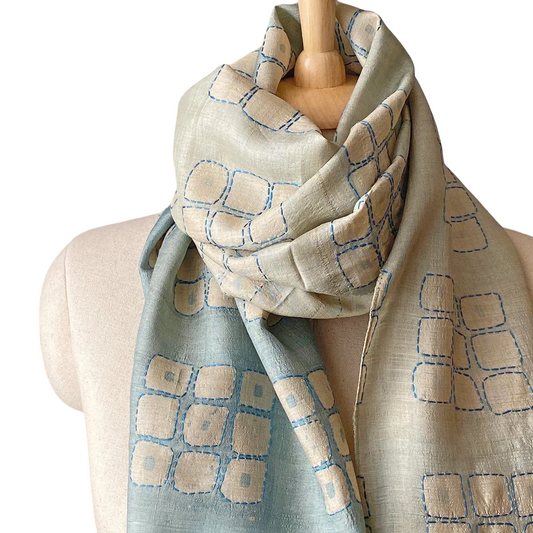 Graduated ombre silk scarf with geometric design wrapped around neck of mannikin.