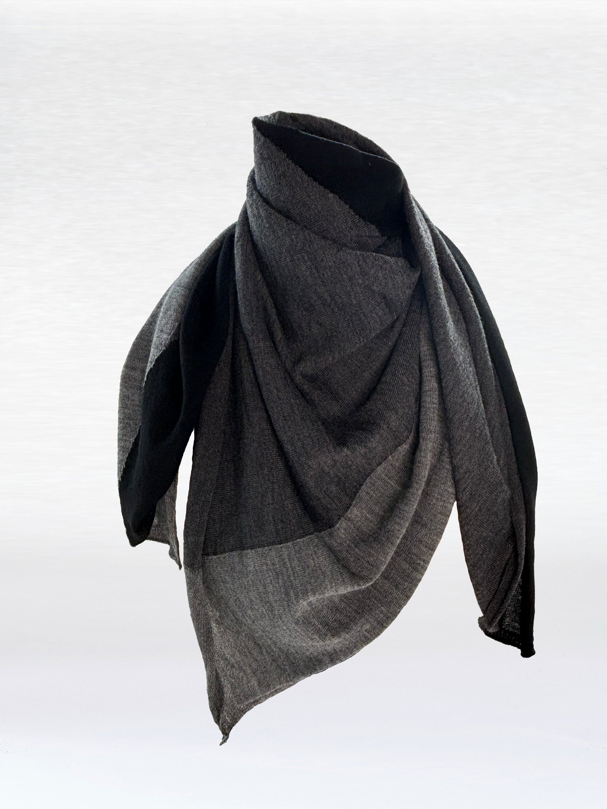 Scarf in black, charcoal, and light grey shaped as if wrapped around a mannikin.