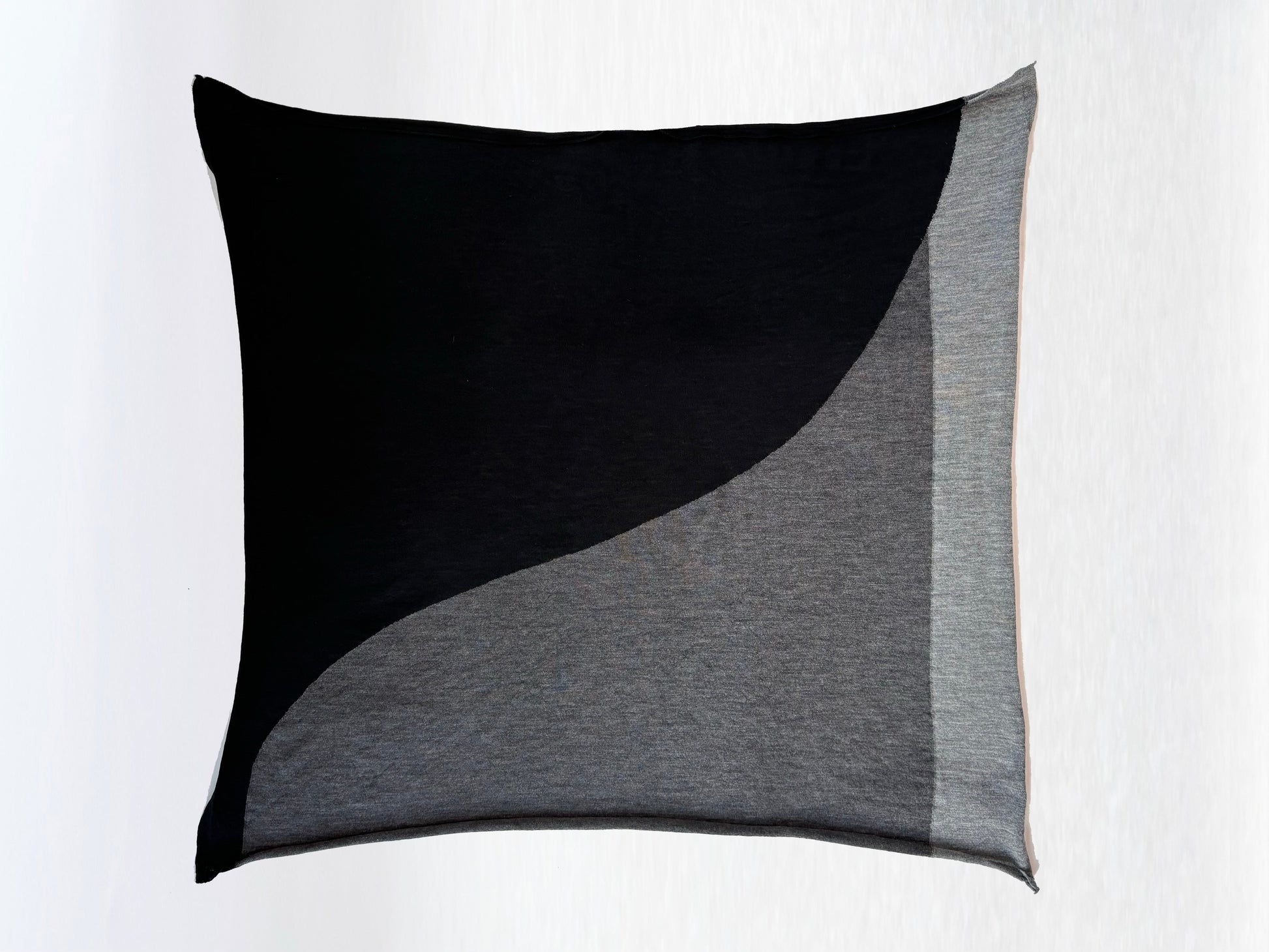 Scarf in black, charcoal, and light grey folded in a square.