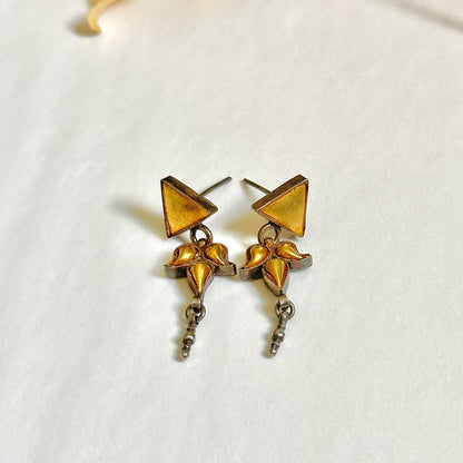 Pair of gold foil earrings with geometric design.