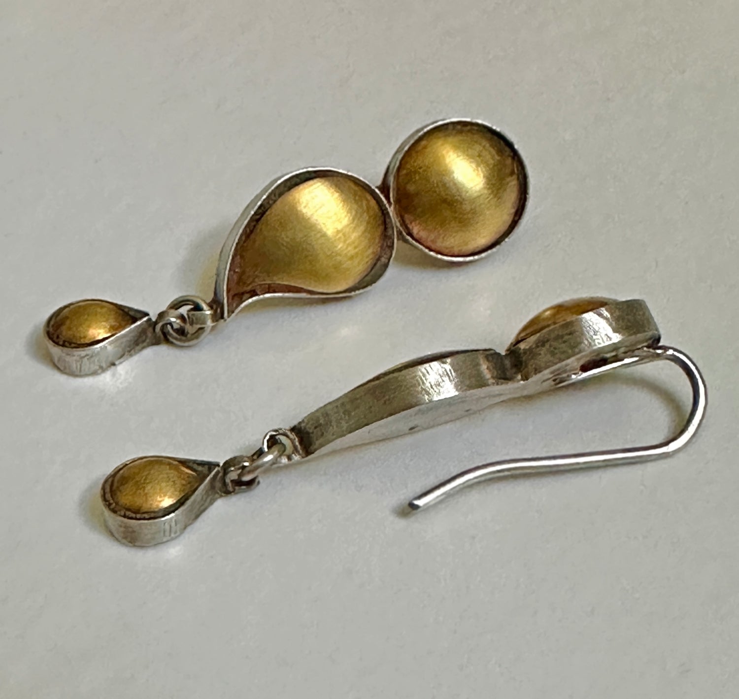 Pair of gold foil earrings with tribal design.