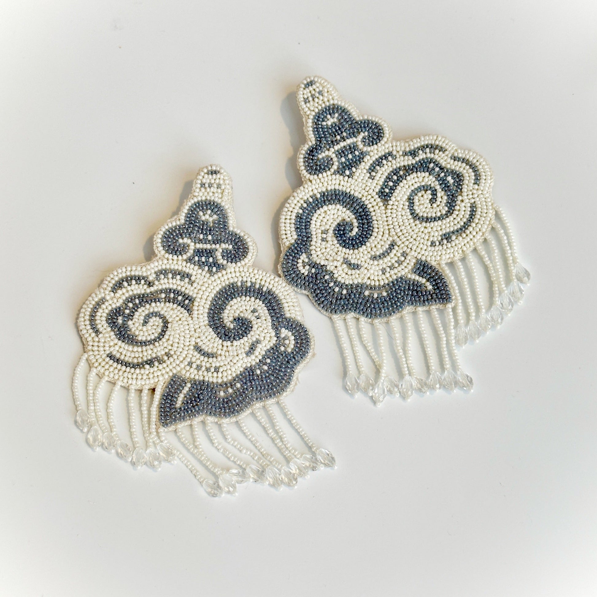 Pair of white and black cloud earrings with tassels.