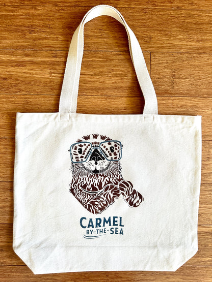 Canvas tote bag with picture of an otter and carmel-by-the-sea written below.