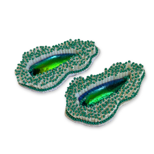 Pair of Pennata beaded green glass earrings with iridescent centers.