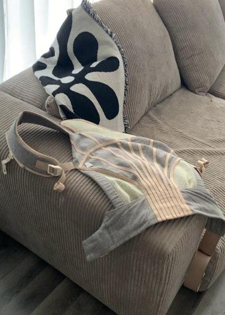 The Corset Carrier Baby Carrier in Stone on sofa.