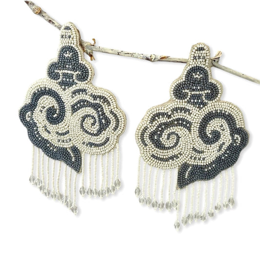Pair of white and black cloud earrings with tassels.