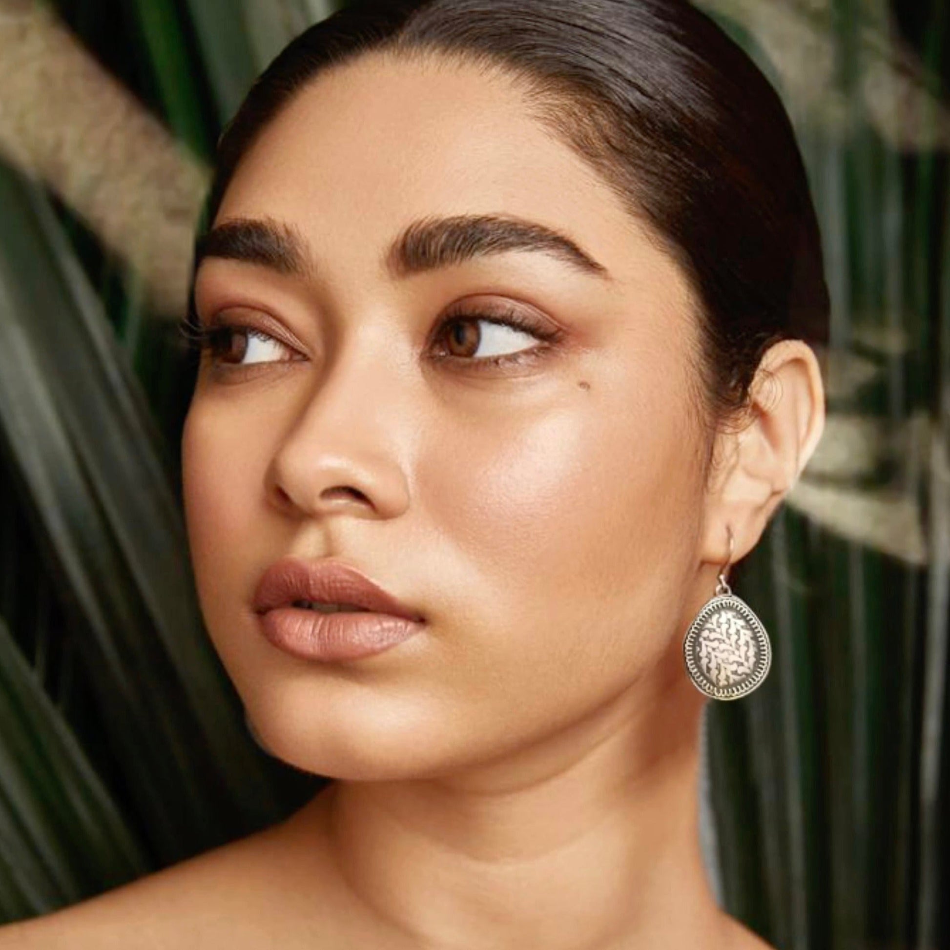 Woman wearing silver earrings.