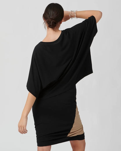 Back view of woman wearing drapey black organic cotton top and skirt..