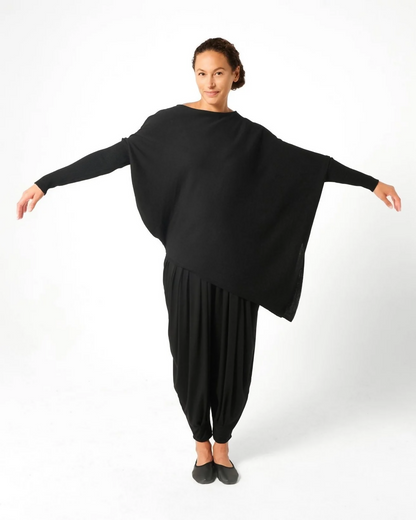 Woman wearing black Italian merino wool drape sweater with black balloon pants.