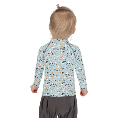 A child wearing a pelican-themed rash guard, showcasing the playful bird design from the back.