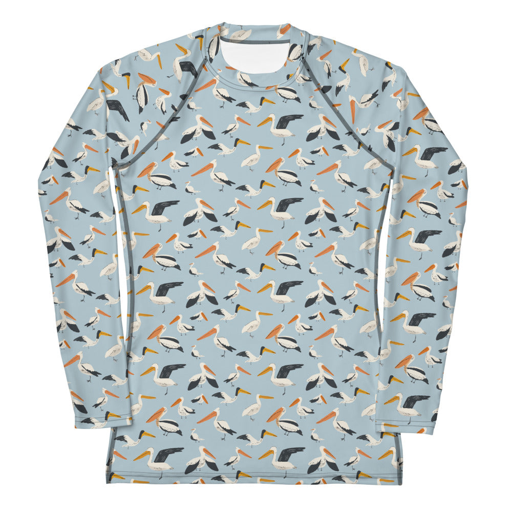 A women’s rash guard featuring a playful pelican print with shades of blue and white, shown from the front.